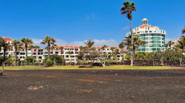 Güzel bir tropikal manzara, yüksek palmiye ağaçları ve zengin siyah volkanik topraklarla çevrili bir tatil beldesine sahiptir.