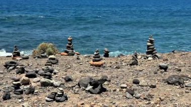 Güzel kıyı şeridi boyunca istiflenmiş kayaların huzurlu manzarası gerçekten huzurlu bir kıyı manzarası yaratır.