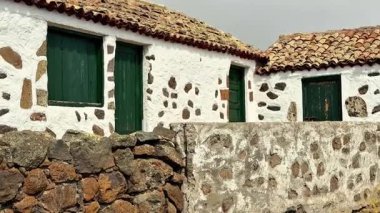 Canlı yeşil panjurlarla bezenmiş geleneksel taş evlerin büyüleyici kırsal güzelliğini keşfedin.