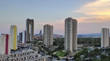 Güzel bir günbatımı sırasında nefes kesici bir şehir silueti modern mimarisini gözler önüne seriyor.