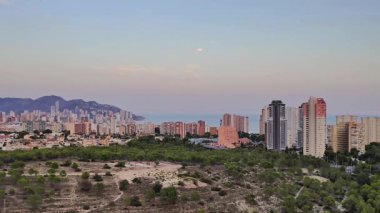 Gün batımında, şehir mimarisi ve huzurlu doğanın ön plana çıktığı kıyı kenti manzarası nefes kesici.