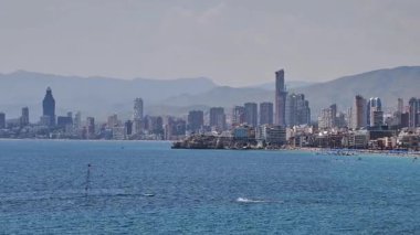 Güzel sahil boyunca uzanan çarpıcı ufuk çizgisi mavi sulara karşı yan yana dizilmiş modern mimariye sahiptir.