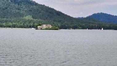 İçinde yelkenlilerin ve büyüleyici küçük bir adanın bulunduğu fevkalade güzel bir dağ gölü.