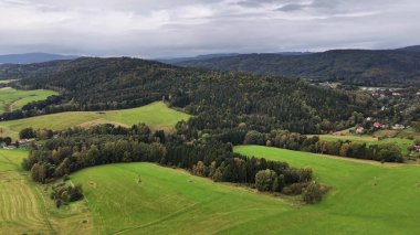 Göz kamaştırıcı bir hava manzarası Geniş yeşil alanlar ve yemyeşil ormanlar Güzel bulutlu bir gökyüzüne karşı kurulmuş