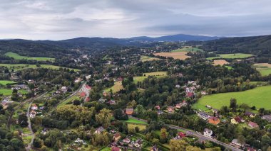Sersemletici hava görüntülerinde güzel bulutlu gökyüzünün altındaki yemyeşil tarlalar ve pitoresk köyler yer alıyor.