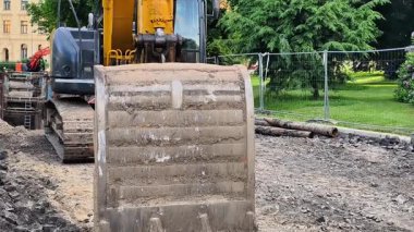 İnşaat alanında kazı yapan bir kazıcı, gelecekte inşa edilecek temeller için alanı temizliyor.