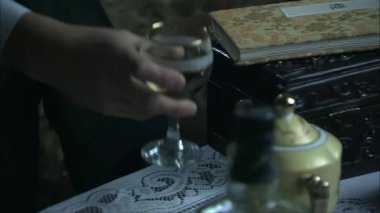 Şarap kadehini eline bırak ve kutudan Tao Te Ching 'i al.