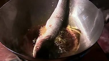 Tavada yağlı balık kızartma.