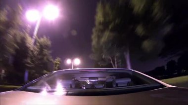 Bir arabanın arka camından gece vakti ışıl ışıl yanan caddelerden geçerken.