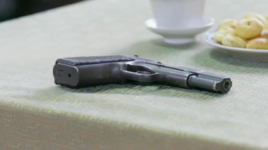 Masadaki tabancanın yakın çekim görüntüsü, yakınlaştırma.