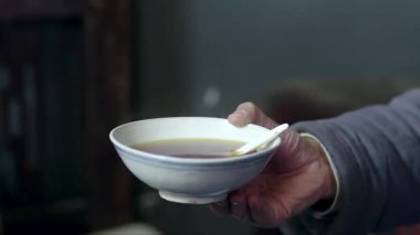 Bir kadın, bir adamdan bir kase Çin ilacı alır. Ellerinin yakın çekim videosu.