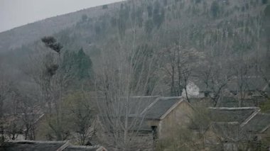 Dağın eteğindeki köyde harap olmuş tuğla ve fayanslı evler.