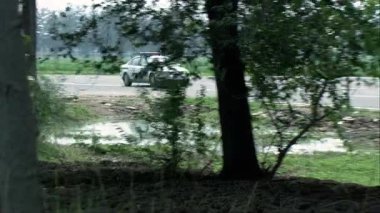  Polis arabası, ağaçlık yolda hız yapıyor. Plakası A8898..
