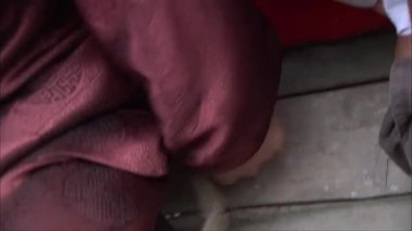 Bir adam gizlice sırtından bir bıçak çıkardı ve onu yanındaki adama uzattı. Yakın çekimde.