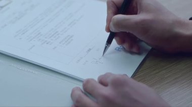 Bir adamın elinin yakın plan bir belgesini imzalıyorum.