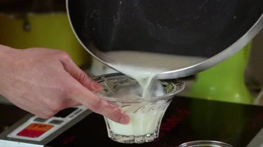 Bir bardak soya sütünü bardaktan bardağa dolduruyorum. Yakın çekim.