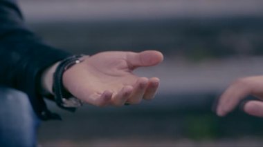 Erkek elini uzatır, kadın alır, yakın plan çekimler yapar.