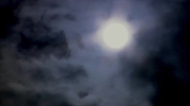 Karanlık bir ay ışığı gecesinde, bulutlar ayın yanından geçti.