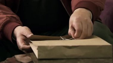 Plastik bandı aç ve bir yığın RMB parası çıkar. Adamın ellerinin yakın plan çekimi..