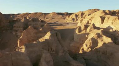 Kuzeybatı Çin 'de rüzgarla aşınmış bir dağın eteğinde yeteneklerini sergileyen motosikletçilerin videosu.