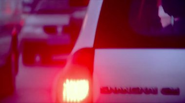 Arabanın stop lambalarının yakın çekimleri akşam bir sokakta çekildi.