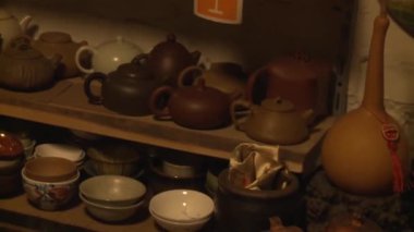 Rafta çeşitli çaydanlıklar ve çay kaseleri var.