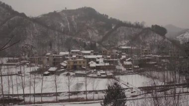 Dağın eteğindeki köy karla kaplı, sabit atış.