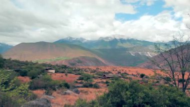 Mavi gökyüzünün ve beyaz bulutların altındaki dağların güzel manzarası.