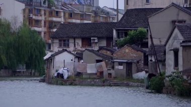 Sudaki evler, evlerin önündeki giysiler kuruyor.