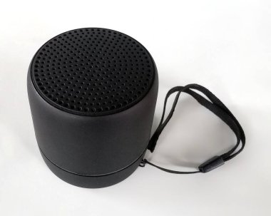 Beyaz bir arka plana yerleştirilmiş, el kayışı olan siyah bir bluetooth hoparlörü. Ürün sunumları, e-ticaret, teknoloji blogları ve tanıtım materyalleri için ideal.