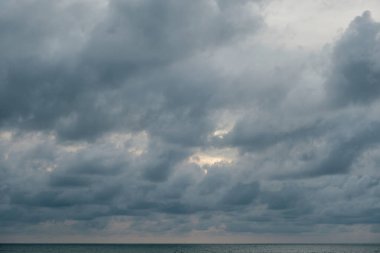 Öğleden sonra geç saatlerde yoğun gri bulutlarla kaplı bir gökyüzü karamsar ve dramatik bir atmosfer yaratıyor. Hava durumu temaları, fırtına arkaplanları ya da çevre ve doğa kavramları için mükemmel.