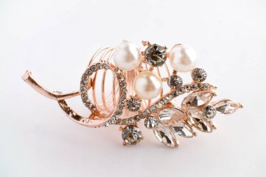 Yapraktan esinlenerek dizayn edilmiş, yuvarlak ve Markiz kesimi saf elmaslı, altın bir gül yüzüğünün yakın çekimi. Ayrıntılı, parlak ve temiz beyaz arka planda zarif..