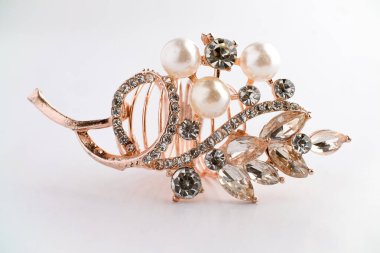 Yapraktan esinlenerek dizayn edilmiş, yuvarlak ve Markiz kesimi saf elmaslı, altın bir gül yüzüğünün yakın çekimi. Ayrıntılı, parlak ve temiz beyaz arka planda zarif..