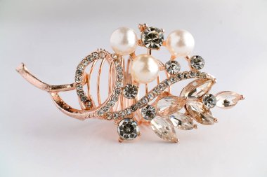 Yapraktan esinlenerek dizayn edilmiş, yuvarlak ve Markiz kesimi saf elmaslı, altın bir gül yüzüğünün yakın çekimi. Ayrıntılı, parlak ve temiz beyaz arka planda zarif..