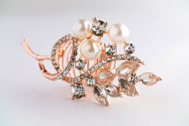 Yapraktan esinlenerek dizayn edilmiş, yuvarlak ve Markiz kesimi saf elmaslı, altın bir gül yüzüğünün yakın çekimi. Ayrıntılı, parlak ve temiz beyaz arka planda zarif..