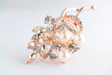 Yapraktan esinlenerek dizayn edilmiş, yuvarlak ve Markiz kesimi saf elmaslı, altın bir gül yüzüğünün yakın çekimi. Ayrıntılı, parlak ve temiz beyaz arka planda zarif..