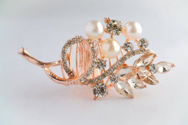 Yapraktan esinlenerek dizayn edilmiş, yuvarlak ve Markiz kesimi saf elmaslı, altın bir gül yüzüğünün yakın çekimi. Ayrıntılı, parlak ve temiz beyaz arka planda zarif..