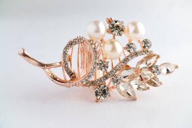 Yapraktan esinlenerek dizayn edilmiş, yuvarlak ve Markiz kesimi saf elmaslı, altın bir gül yüzüğünün yakın çekimi. Ayrıntılı, parlak ve temiz beyaz arka planda zarif..