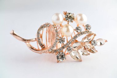 Yapraktan esinlenerek dizayn edilmiş, yuvarlak ve Markiz kesimi saf elmaslı, altın bir gül yüzüğünün yakın çekimi. Ayrıntılı, parlak ve temiz beyaz arka planda zarif..