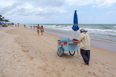 Recife, Brezilya 'da kumsalda yemek arabası süren bir adam, ziyaretçilere atıştırmalık satıyor..