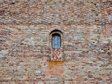 Church facade - bricked-up window detail. Church facade detail captures historic window structures, revealing architectural beauty and cultural heritage of the building. clipart