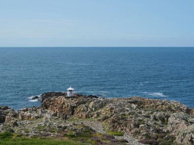 Deniz feneri - İsveç 'te küçük beyaz deniz feneri Kullaberg. Kullaberg 'in İsveç' teki Kullaberg kayalık sahilindeki küçük beyaz deniz feneri. Arkaplan, tasarım ve metin alanları kadar uygun.