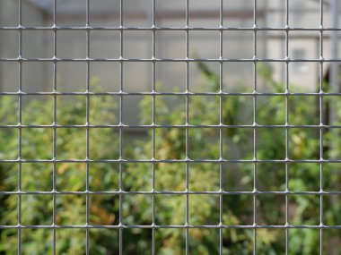 Tavşan kafesinden kablo örgüsü. Ağ hayvanları insanlardan ve yırtıcı kuşlardan korur, ağ yapısını aydınlatır. Arkaplan, tasarım ve metin alanları kadar uygun.