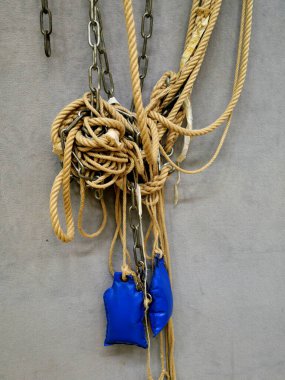 Bağlı, eski bir spor salonunda yıpranmış tırmanma ipleri izinsiz tırmanışı engeller. Yıpranmış uçlar yıllarca kullanıldığını gösteriyor. Metin ve tasarım için boşluk.