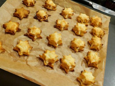 Noel yıldızları şeklinde elma dolgulu fırınlanmış poğaça kurabiyeleri. Lezzetli ve popüler bir ikram. Tatil ve şenlik için mükemmel. Metin için boşluk.