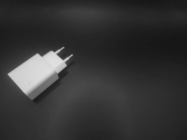 Siyah arkaplanı olan beyaz şarj adaptörü 