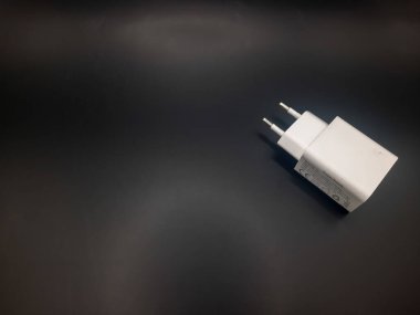 Siyah arkaplanı olan beyaz şarj adaptörü 