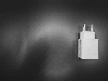 Siyah arkaplanı olan beyaz şarj adaptörü 