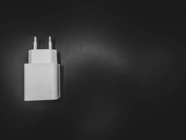 Siyah arkaplanı olan beyaz şarj adaptörü 