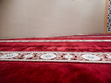 Caminin zemininde kırmızı halı var. 
